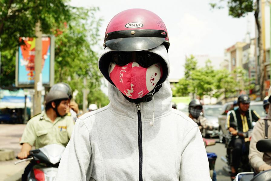 Teen-ager with a pink mask and gray sweater 