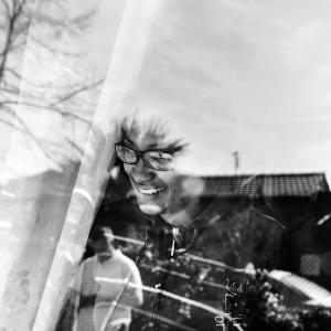 Nelly controlla da dietro la finestra della sua nuova situazione abitativa, una piccola chiesetta alla periferia di Roma,il gioco dei suoi 2 figli