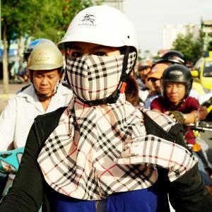 Girl with Burberry plaid accessories "Cover-up Style" driving on the streets of H.C.M.C. Girl with Burberry plaid accessories